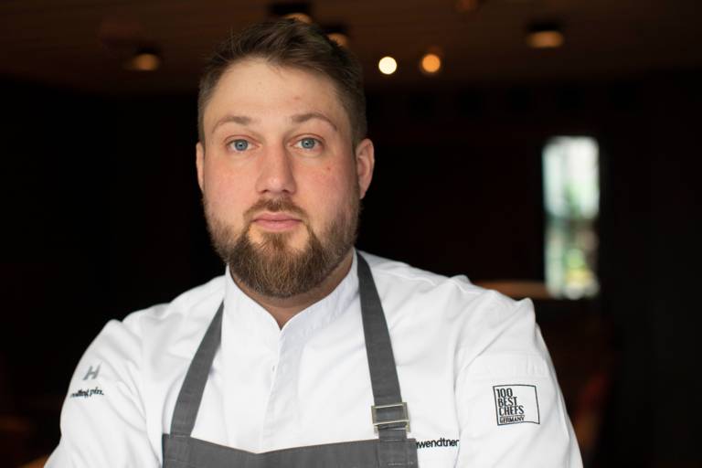 A portrait of star chef Anton Gschwendtner in a chef's apron