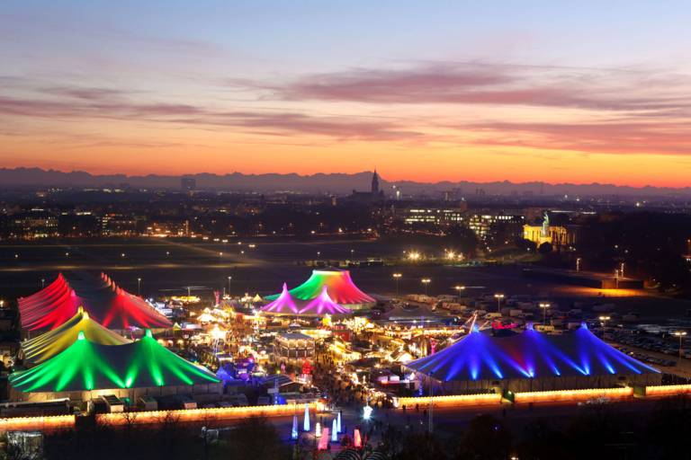 Blick von oben auf das beleuchtete Tollwood-Winterfestival in München.