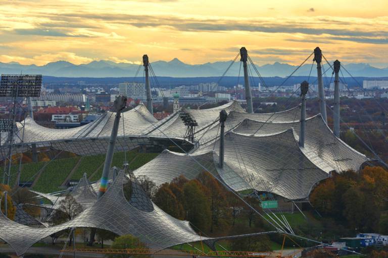 Das Olympiazeltdach in München vor der Alpenkette