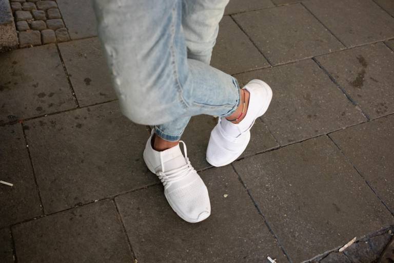 A man's jeans and white sneakers in Munich. 