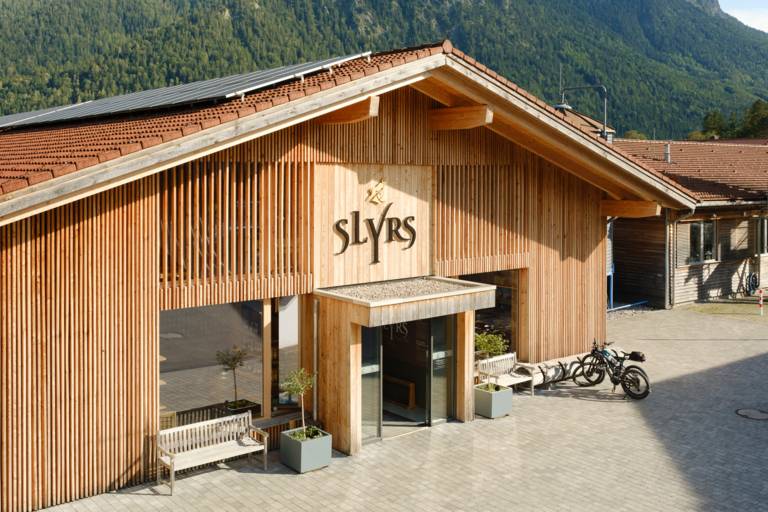 The wooden building with a view of the main entrance to the Slyrs distillery