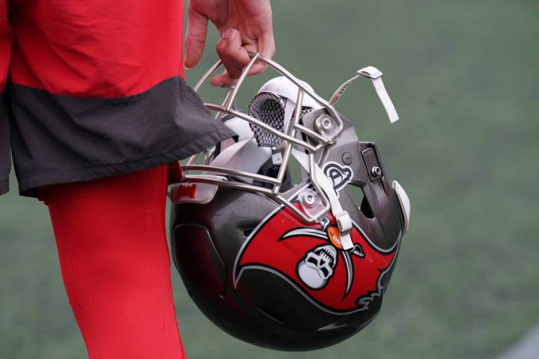 Bildausschnitt von der Hand eines Spielers, die einen Football-Helm hält.