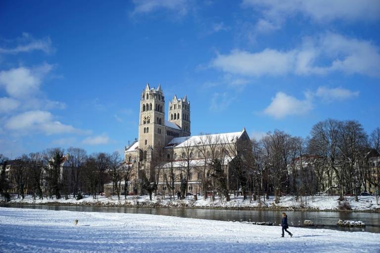 Schneebedecktes Flussufer und Kirche in München
